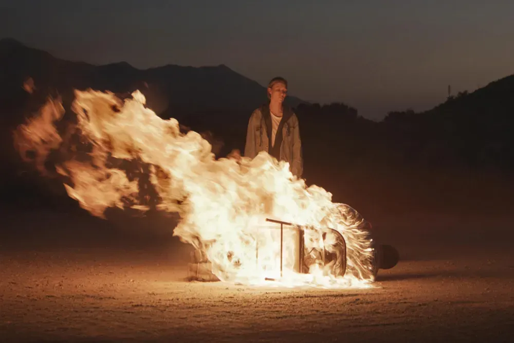 Still from Redux Redux of Michaela McManus standing in the desert watching a man burn alive.