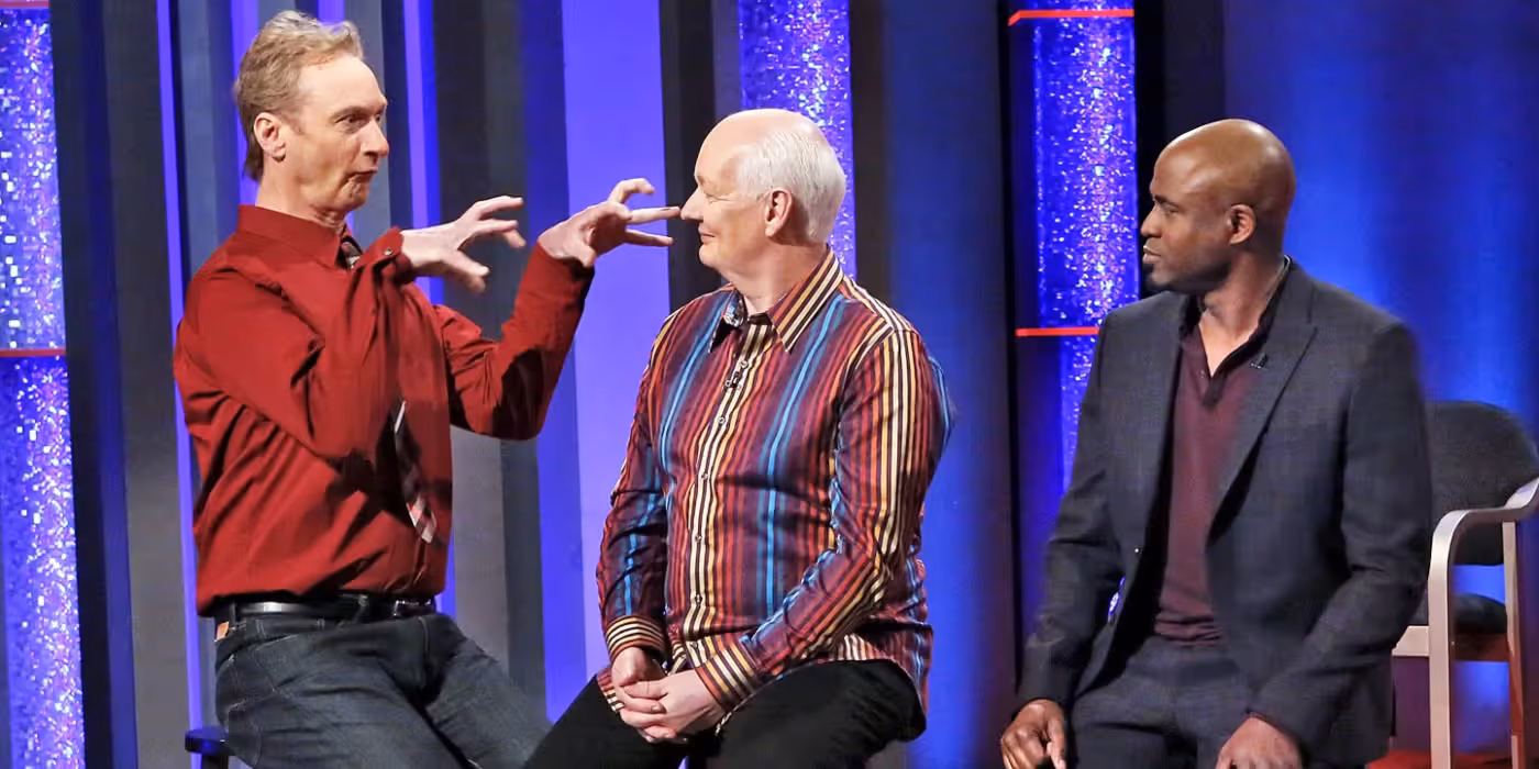 Ryan Stiles, Colin Mochrie, and Wayne Brady in Whose Line Is It Anyway. Ryan appears to be imitating a dinosaur.